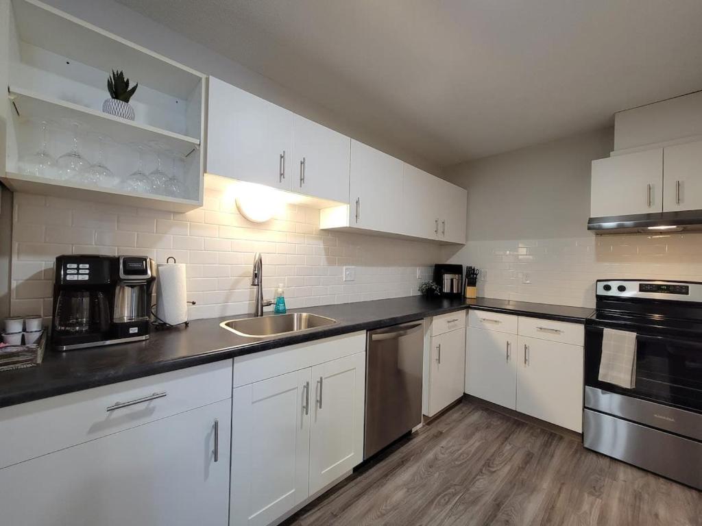 una cocina con armarios blancos y fregadero en 2 Bedroom 2 Bath Apartment Near Mayo, Park Free! en Rochester