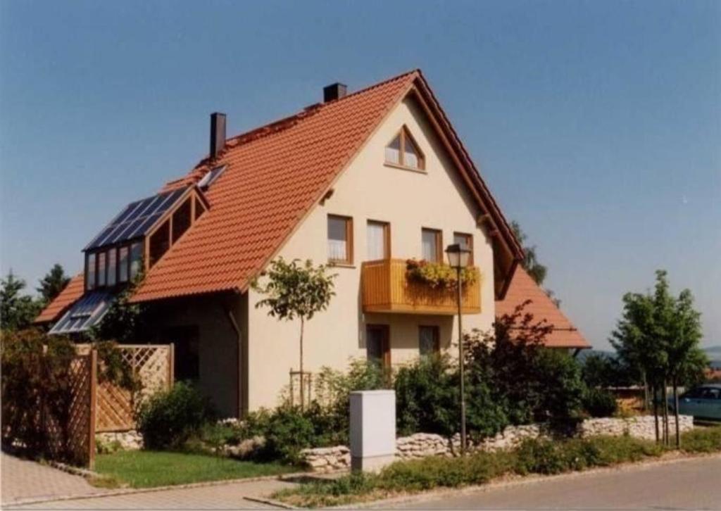 a large white house with an orange roof at Komfortable Ferienwohnung in Ebensfeld mit Garten und Grill in Ebensfeld