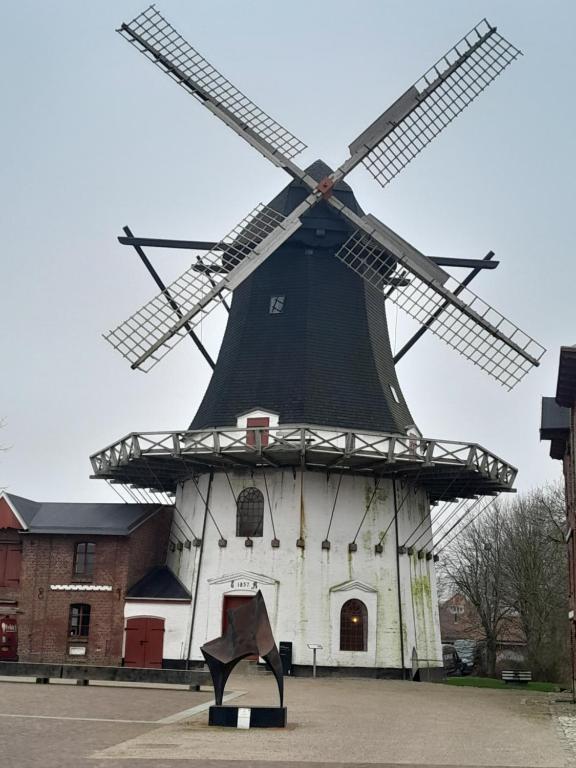 a large windmill with a statue in front of it at Apartment mit 2 Zimmern und Balkon im Herzen von Høyer in Højer