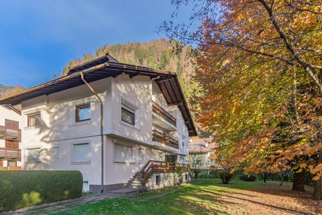a white house with a gambrel roof at CASA PINUCCIA MANSARDA in Predazzo