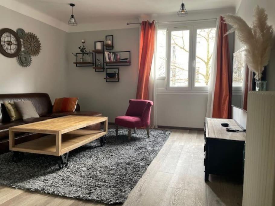 un salon avec un canapé et une table dans l'établissement Cosy appartement proche de Paris, à Le Raincy