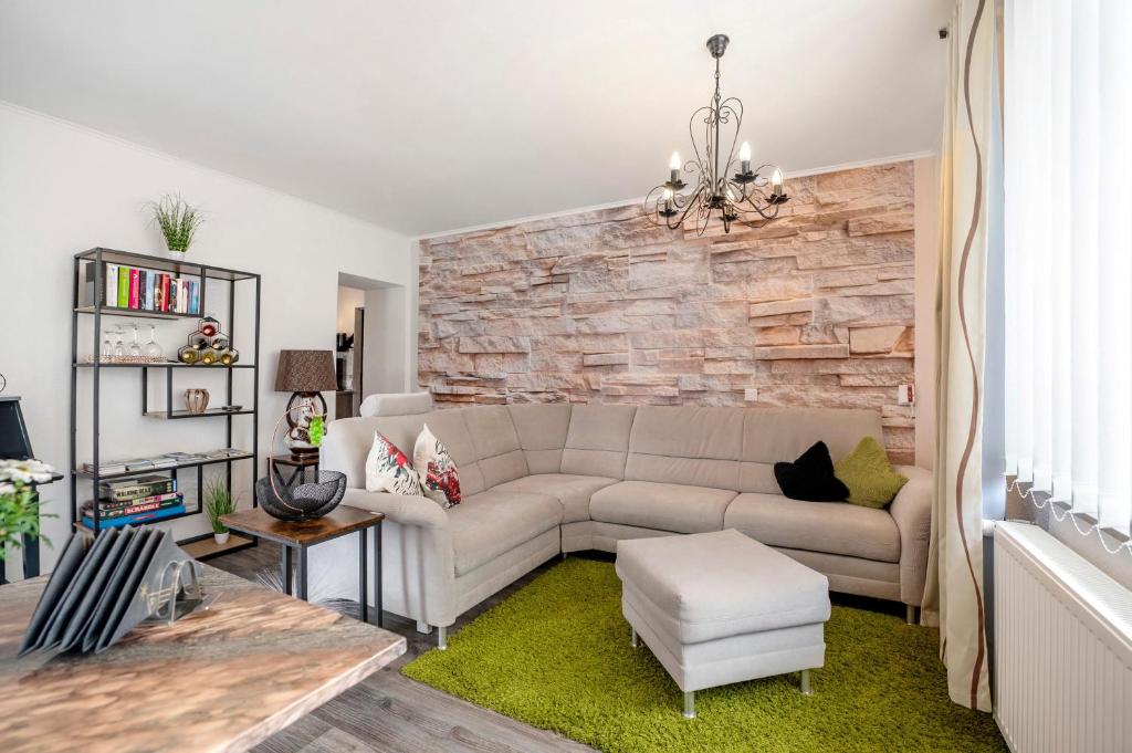 a living room with a couch and a stone wall at Bellevie in Kell