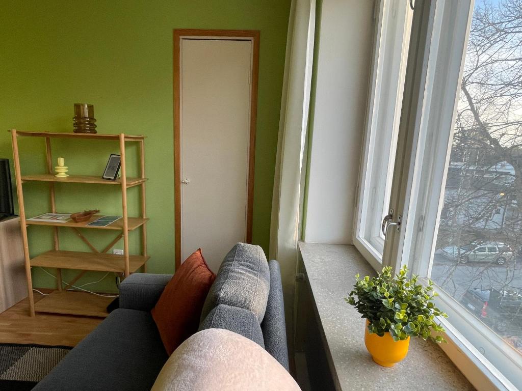 a living room with a couch and a window at The Golden Glow Apartment Turku in Turku