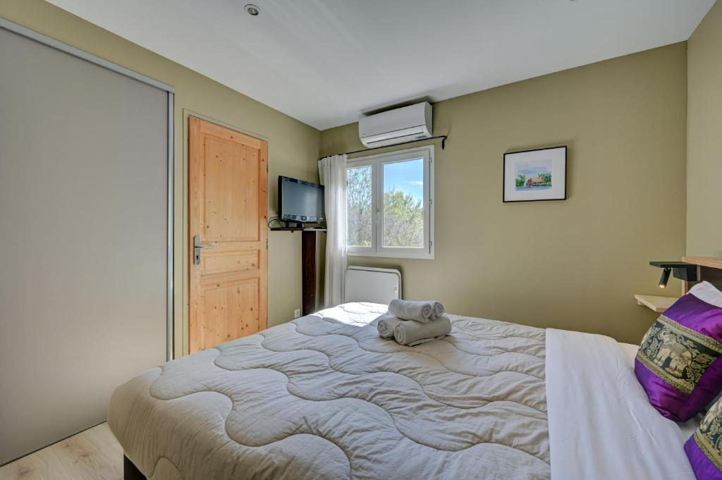 a bedroom with a large bed with a stuffed animal on it at Hostellerie Le Paradou in Lourmarin