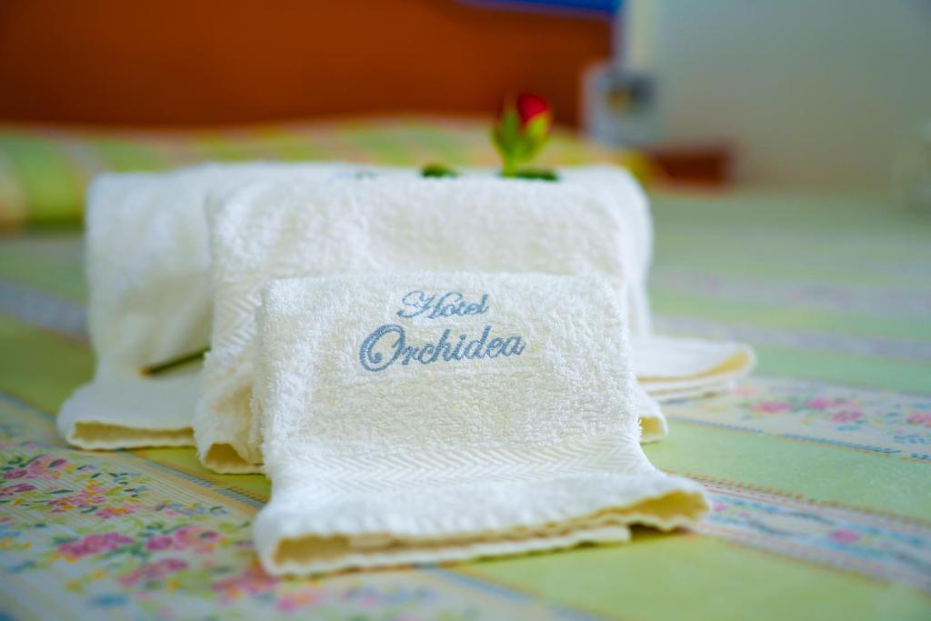 Biały ręcznik ze słowami gorącej krytyki napisanymi na nim w obiekcie Hotel Orchidea w mieście Peschici