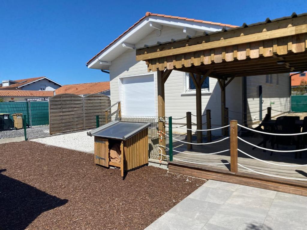 une arrière-cour avec une cabane pour chiens et un pavillon dans l'établissement Maison la teste, à La Teste-de-Buch