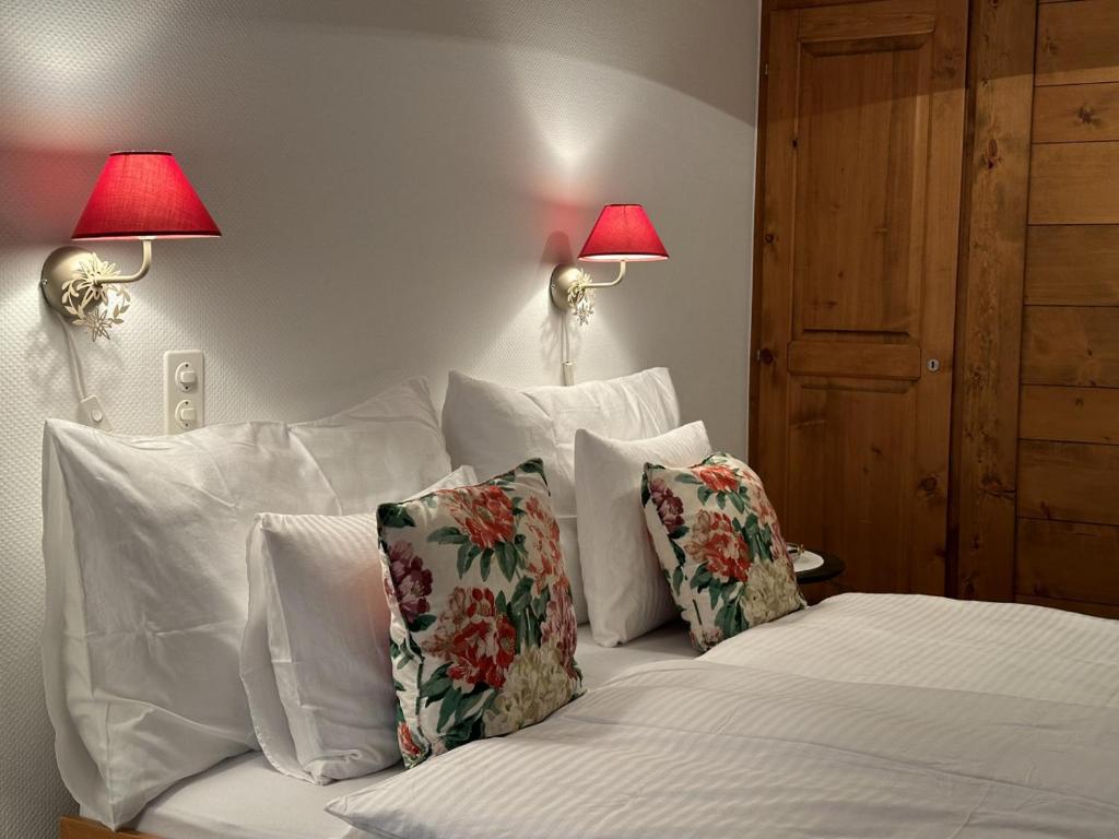 1 dormitorio con 1 cama con almohadas y 2 lámparas en Granny Chic Mountain Hideaway en Gstaad
