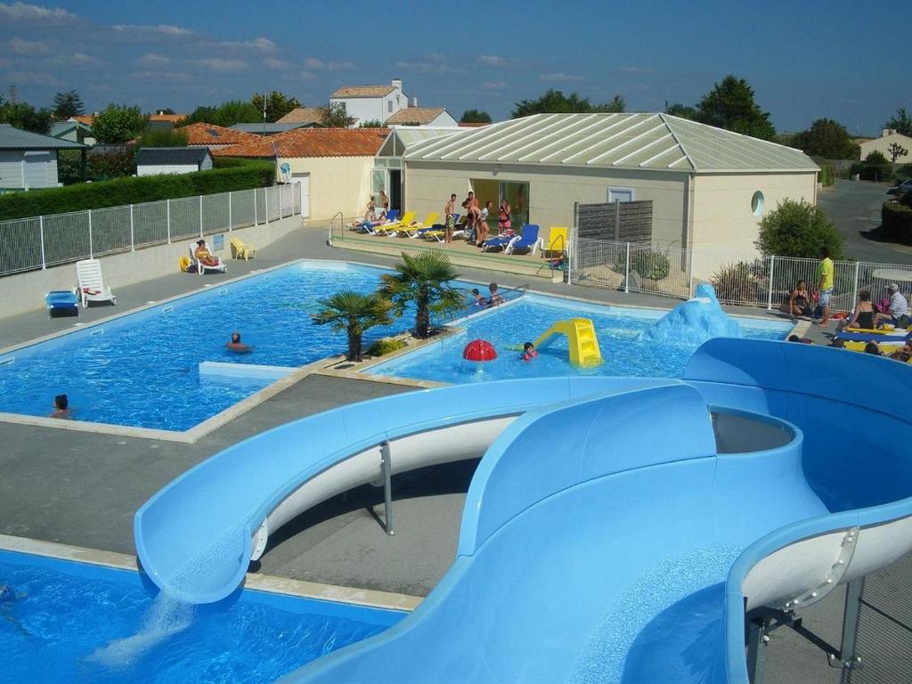 une grande piscine avec un parc aquatique doté d'un toboggan. dans l'établissement Posadom, Mobil Home 82 avec piscine, à Brem-sur-Mer