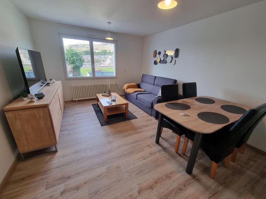 un salon avec un canapé bleu et une table dans l'établissement Appartement Mers les Bains à 1km de la plage, à Mers-les-Bains