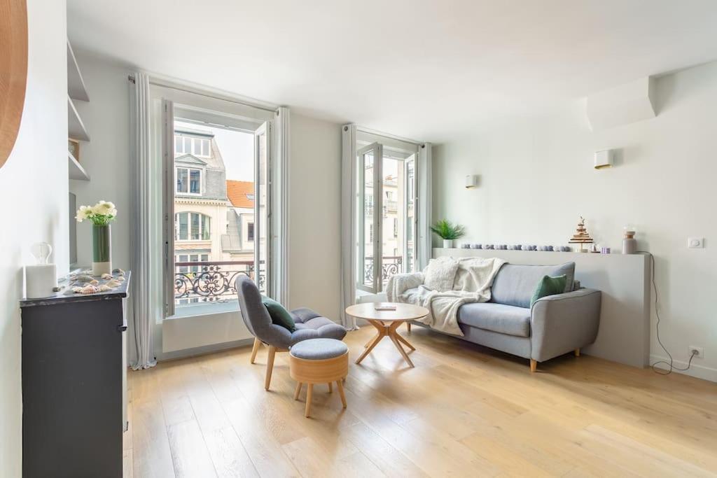 ein Wohnzimmer mit einem Sofa und einem Tisch in der Unterkunft Bastille nest in Paris in Paris