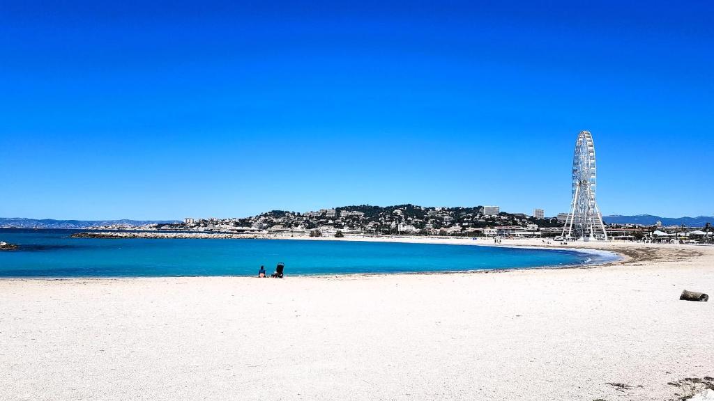 uma praia branca com um corpo azul de água em maison plages et calanques 4/6 personnes em Marselha