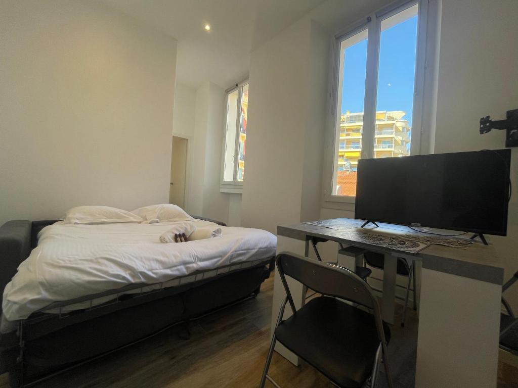 une chambre avec un lit et un bureau avec un ordinateur dans l'établissement Charmant 2 pièces moderne centre ville -BEG-, à Cannes