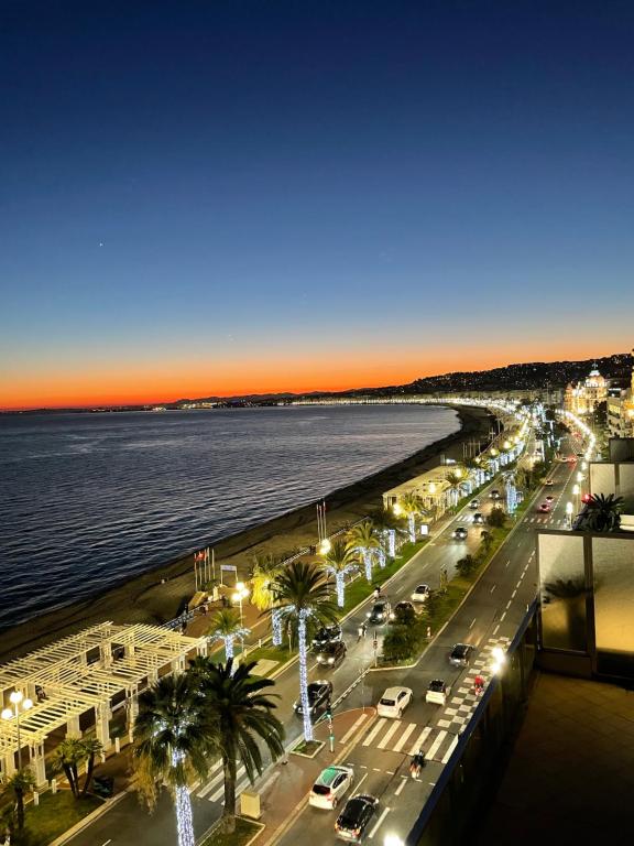 une ville avec une plage et l'océan la nuit dans l'établissement Royal lux promenade des anglais, à Nice