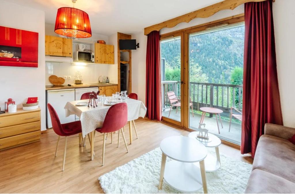 a kitchen and a living room with a table and chairs at Appart Orelle 2101 in Orelle