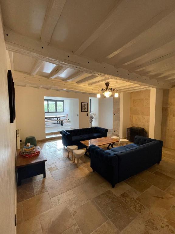 un grand salon avec des canapés et une table dans l'établissement La Poserie des Monts et Vallées, à Esson