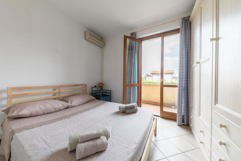 a bedroom with a bed and a large window at Villa vicino al mare con giardino e parcheggio in Cinquale