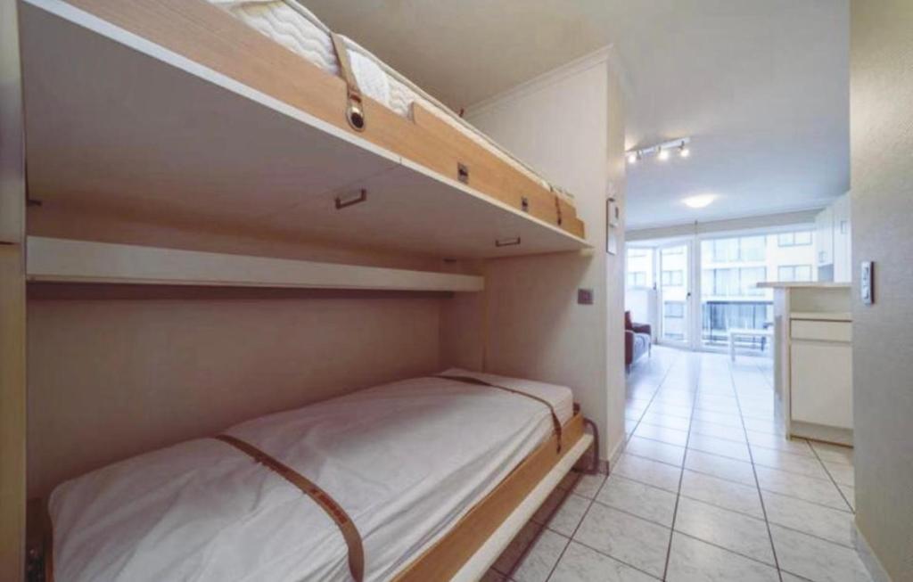een slaapkamer met 2 stapelbedden en een keuken bij Studio Sia - Lichtrijke studio met balkon met zijzeezicht in hartje de Panne in De Panne