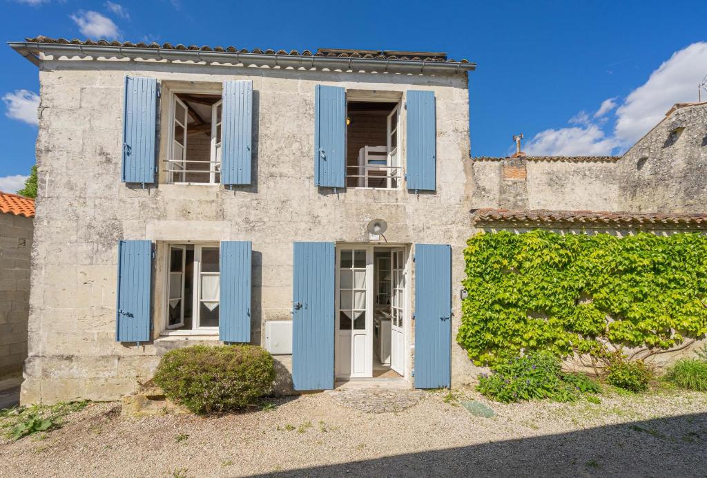 Une vieille maison avec volets bleus et lierre dans l'établissement Isatis, à Mortagne-sur-Gironde