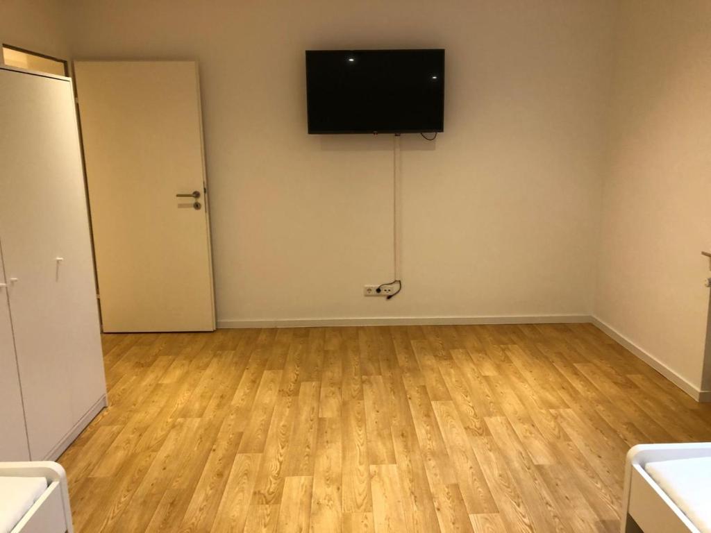 an empty room with a flat screen tv on a wall at Möbilierte 3 Zimmer Wohnung mit großer Wohnküche in Dossenheim