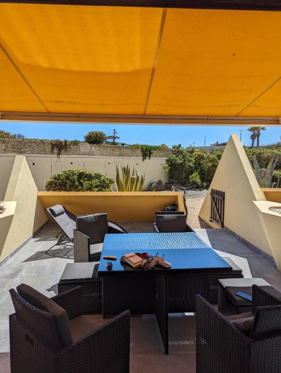 un patio avec une table et des chaises sur un toit dans l'établissement Sexy Dream Heliopolis, au Cap d'Agde