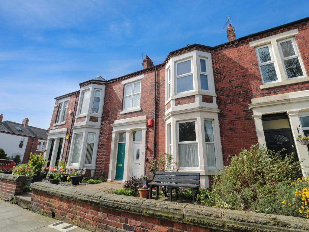 a row of brick houses with a bench in front at 14 Birtley Avenue in North Shields