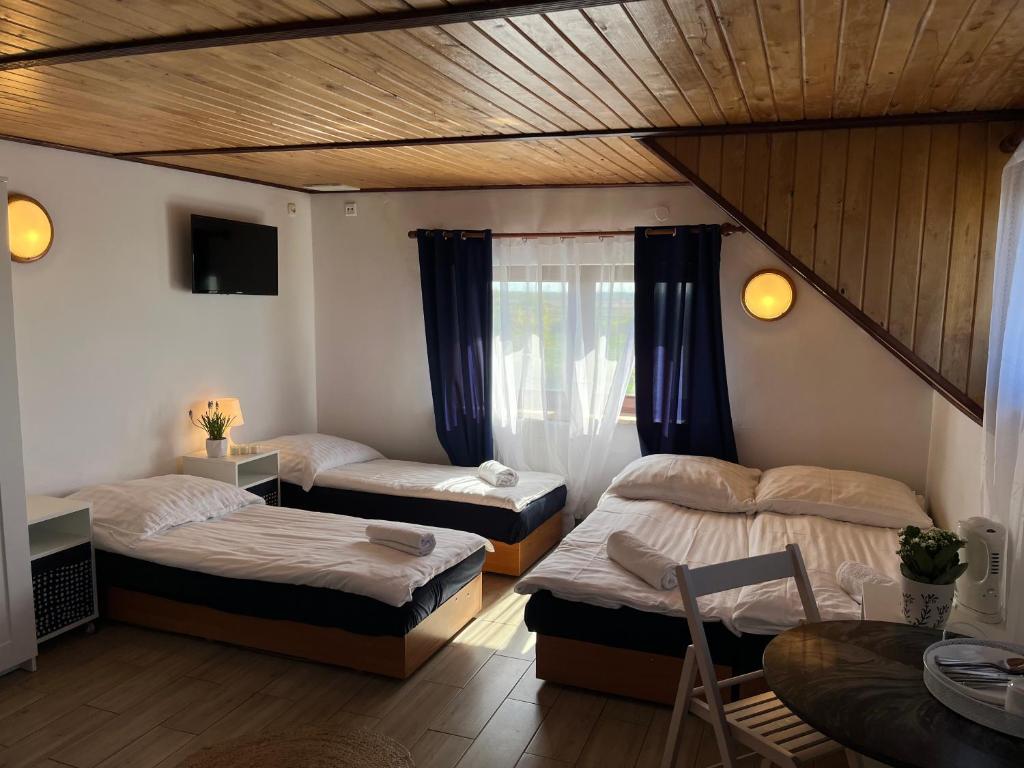 a bedroom with two beds and a table at Dom Wypoczynkowy Morski Oddech in Łeba