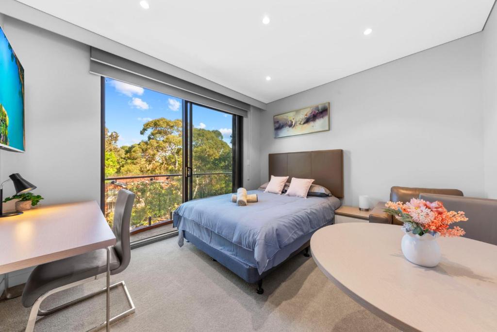 a bedroom with a bed and a desk and a table at Nice and quite studio Roseville in Sydney