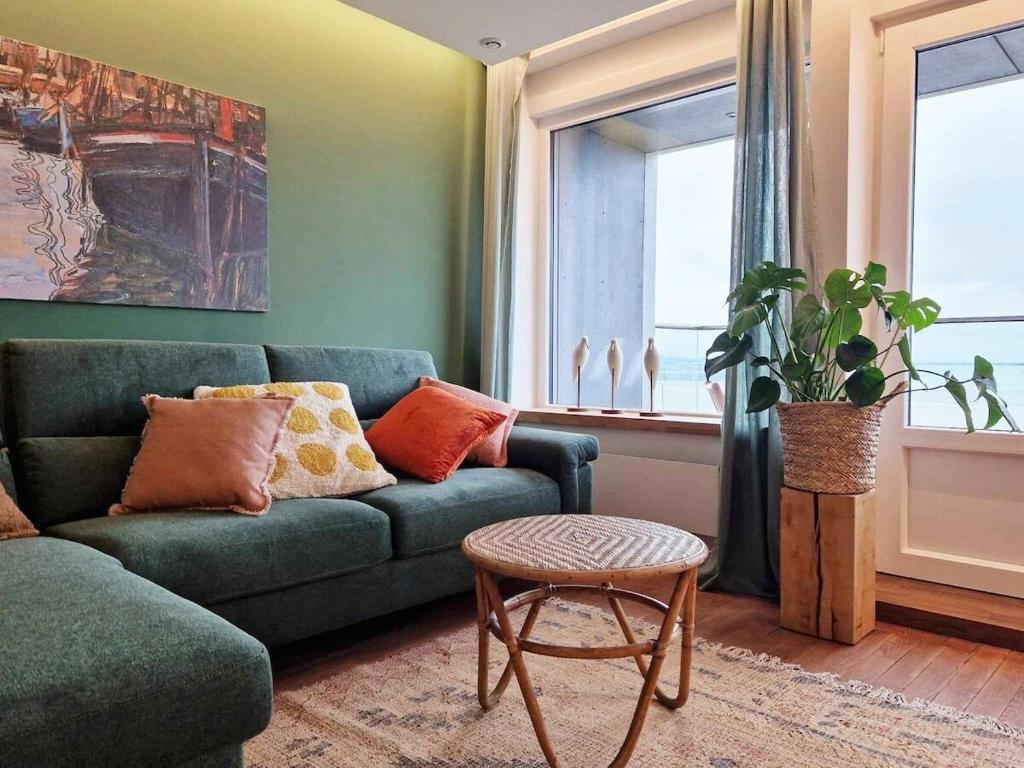 a living room with a green couch and a table at Descente à la mer in Boulogne-sur-Mer