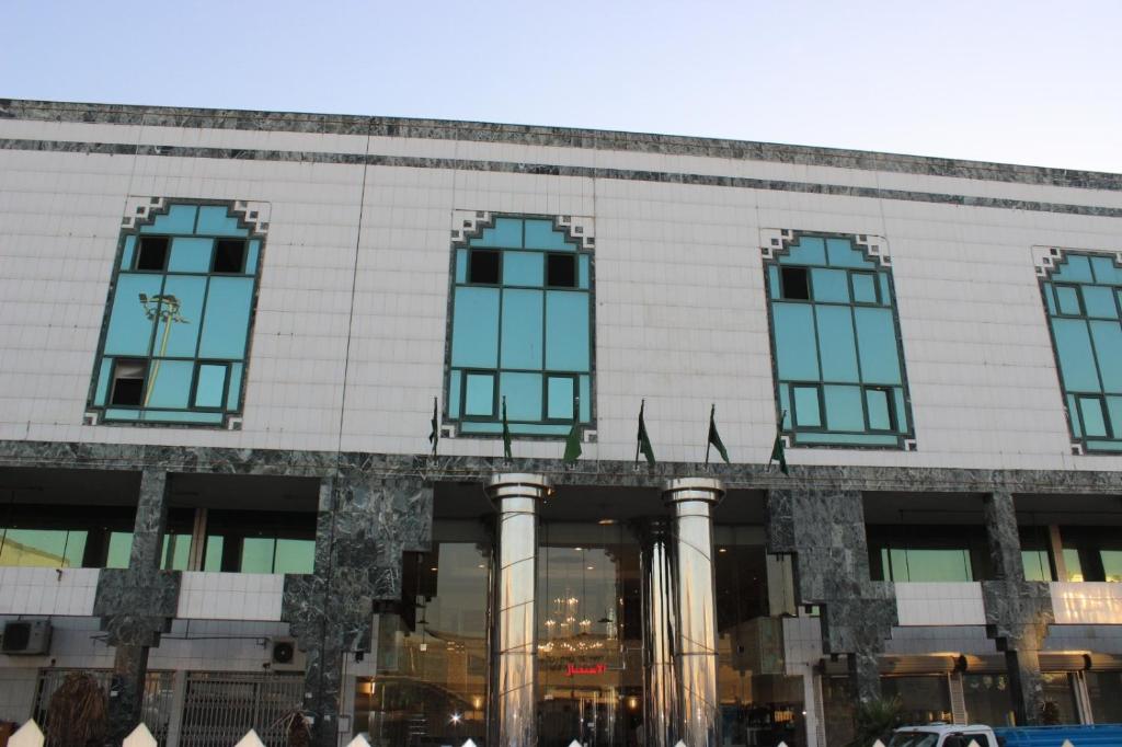 فندق سرر المحمديه الرياض في الرياض: مبنى فيه نوافذ زرقاء واعلام امامه