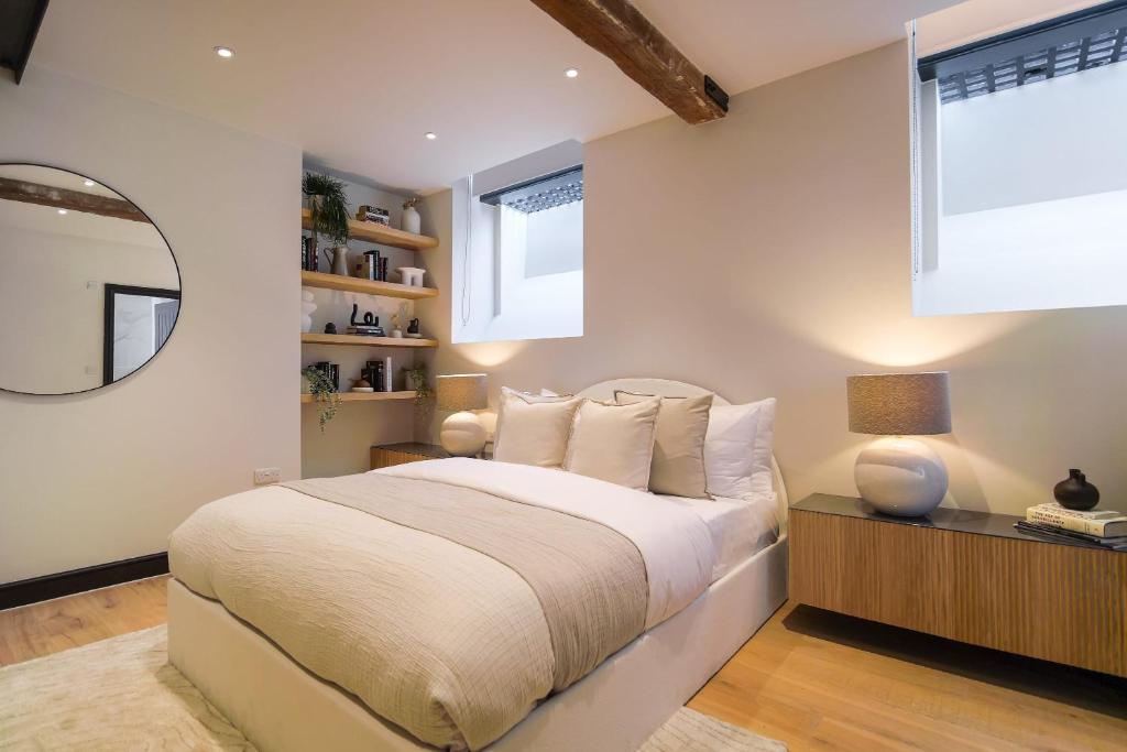 a bedroom with a large bed and a mirror at Omnia by The Heim Residences in Manchester
