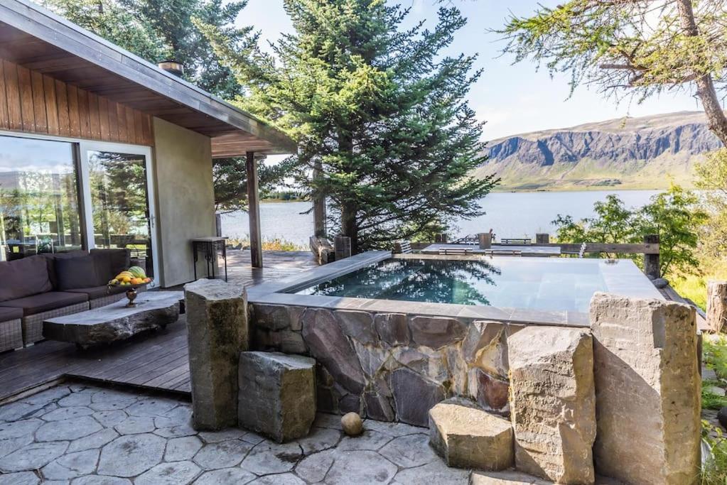 ein Schwimmbad in der Mitte eines Hauses in der Unterkunft Luxury Lakefront villa, infinity hot tub and sauna in Grímsnes og Grafningshreppur