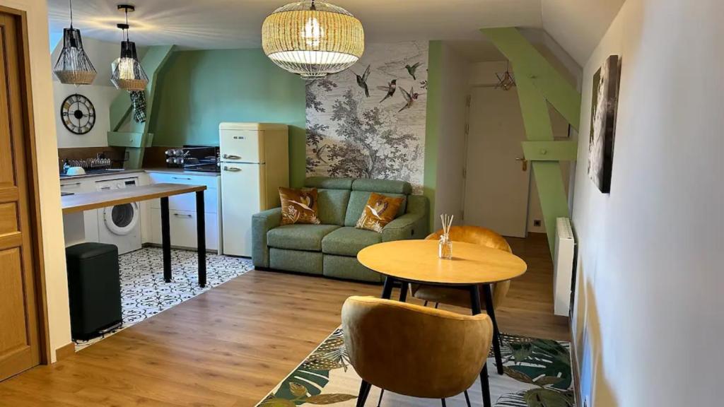 een keuken en woonkamer met een tafel en een bank bij Tout à pied Dourdan Appartement in Dourdan