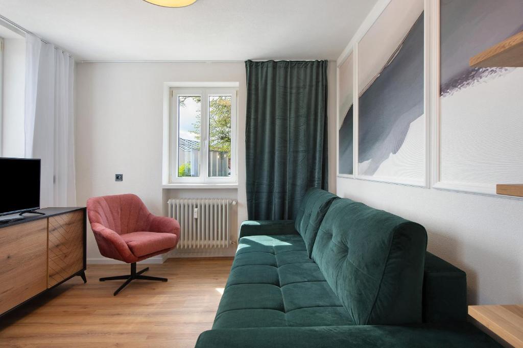 salon z zieloną kanapą i krzesłem w obiekcie Ferienwohung Forestdreams w mieście Weilheim
