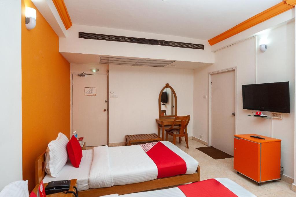 チェンナイにあるManhattanのベッド2台、薄型テレビが備わるホテルルームです。