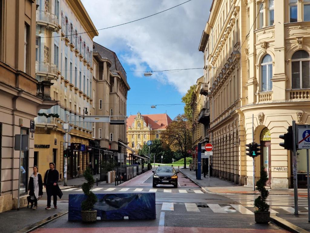 una strada cittadina con un'auto che percorre una strada di Tiskara 1897 a Zagabria