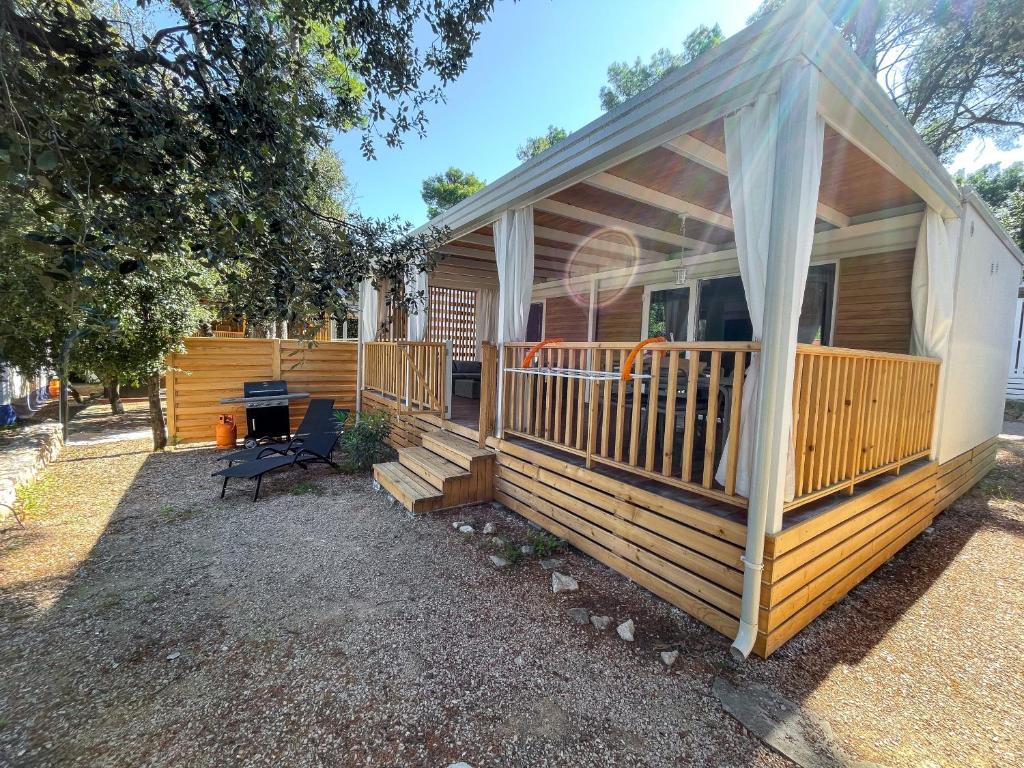 une maison avec une grande terrasse couverte dans l'établissement Mobile Home Symphony, à Biograd na Moru