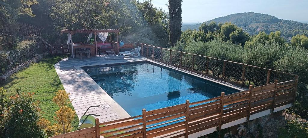 une piscine entourée d'une clôture en bois. dans l'établissement Villa avec piscine, vue panoramique ste victoire, à Simiane-Collongue