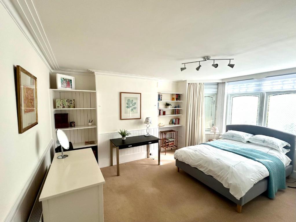 East Finchley N2 apartment close to Muswell Hill & Alexandra Palace with free parking on-site في لندن: غرفة نوم فيها سرير ومكتب