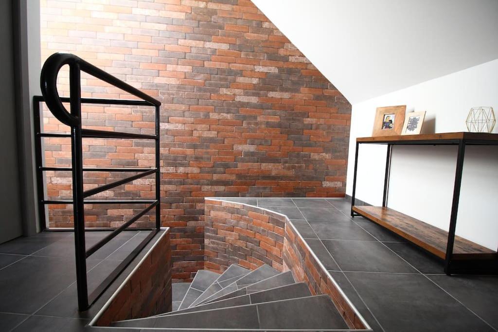Cette chambre est dotée d'un mur en briques et d'un escalier. dans l'établissement T2 atypique, entièrement rénové, quartier Soulages, à Rodez
