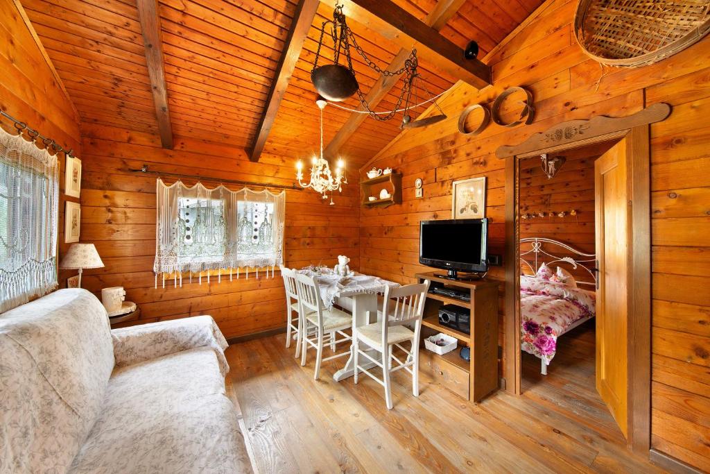 a dining room with a table and a television in a cabin at Orserose Chalet 1 La Bilancia in Forno di Zoldo