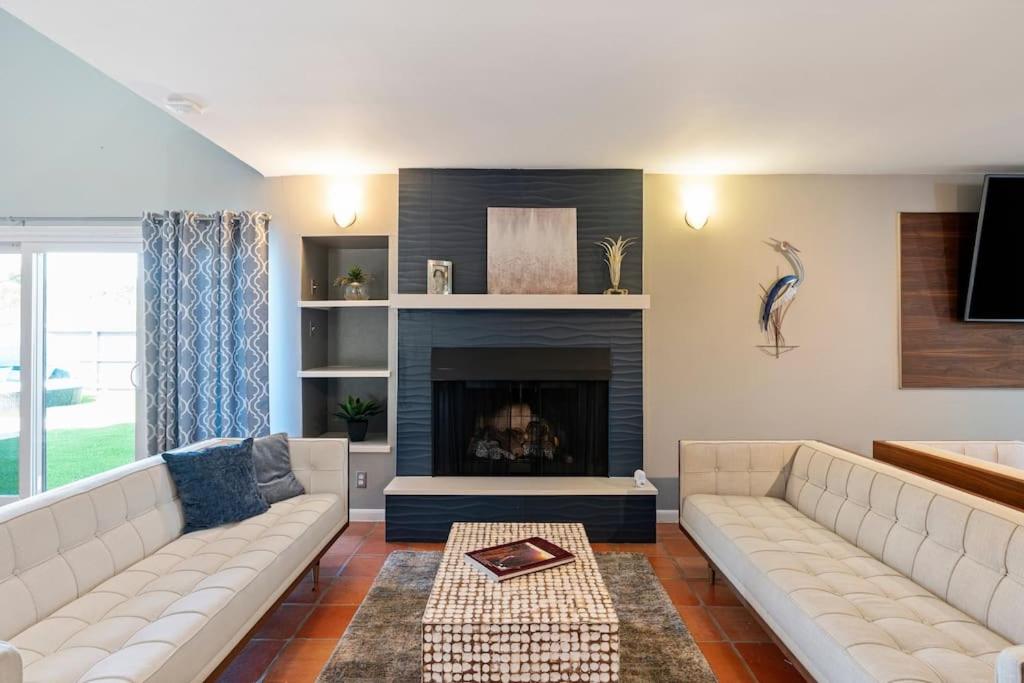 ein Wohnzimmer mit Couch und Kamin in der Unterkunft Ocean Drive Oasis w Hot Tub Awaits in Corpus Christi