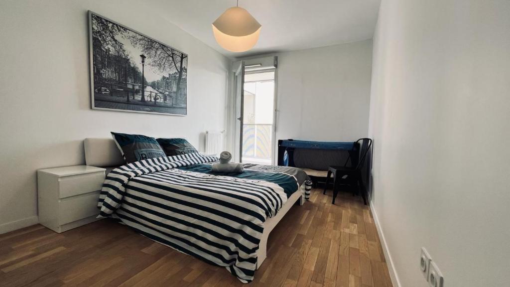 a bedroom with a bed with a black and white striped blanket at Lumière Paris, Appt 66m2, FREE Parking, Terrasse, Ascenseur et Metro L13 in Malakoff