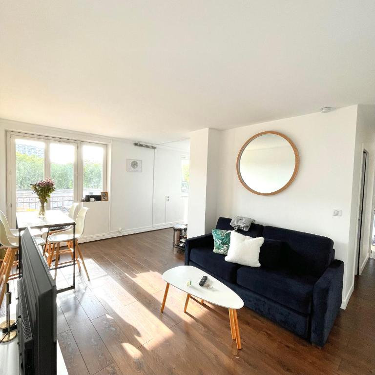 ein Wohnzimmer mit einem Sofa und einem Tisch in der Unterkunft Shiny apartment - Direct line to Olympic Village in Clichy