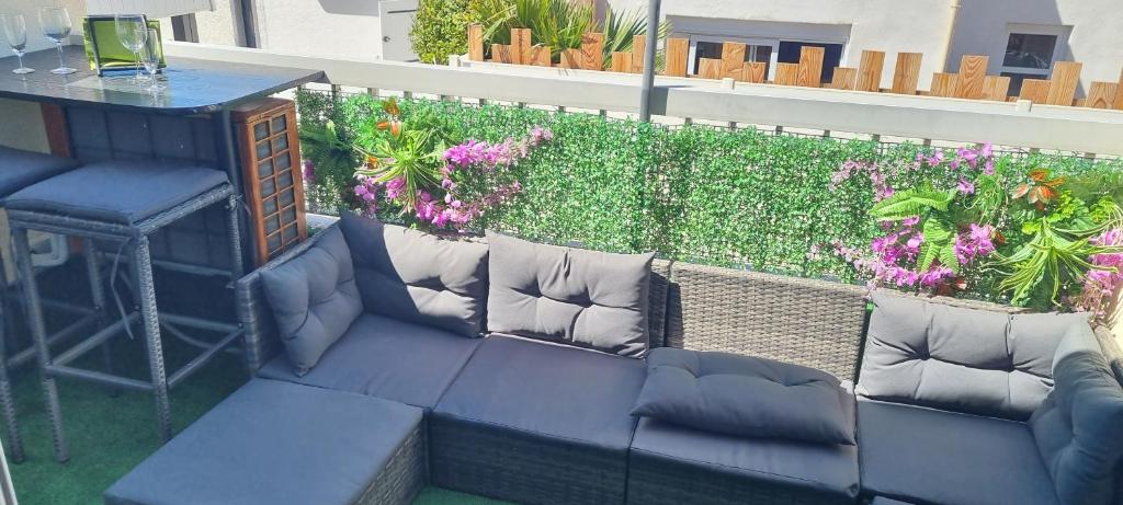 un canapé assis au sommet d'un balcon avec des fleurs dans l'établissement Naturiste Soleil New, au Cap d'Agde
