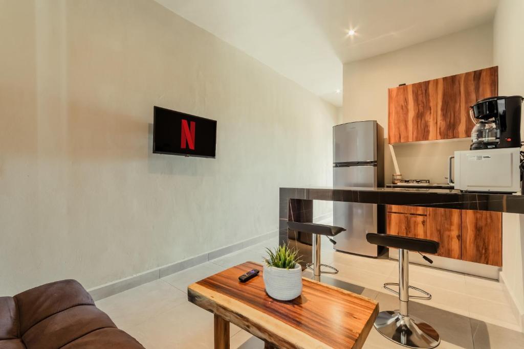a living room with a coffee table and a kitchen at CASA ALDAMA- Style & Convenient Apartments in Cancún
