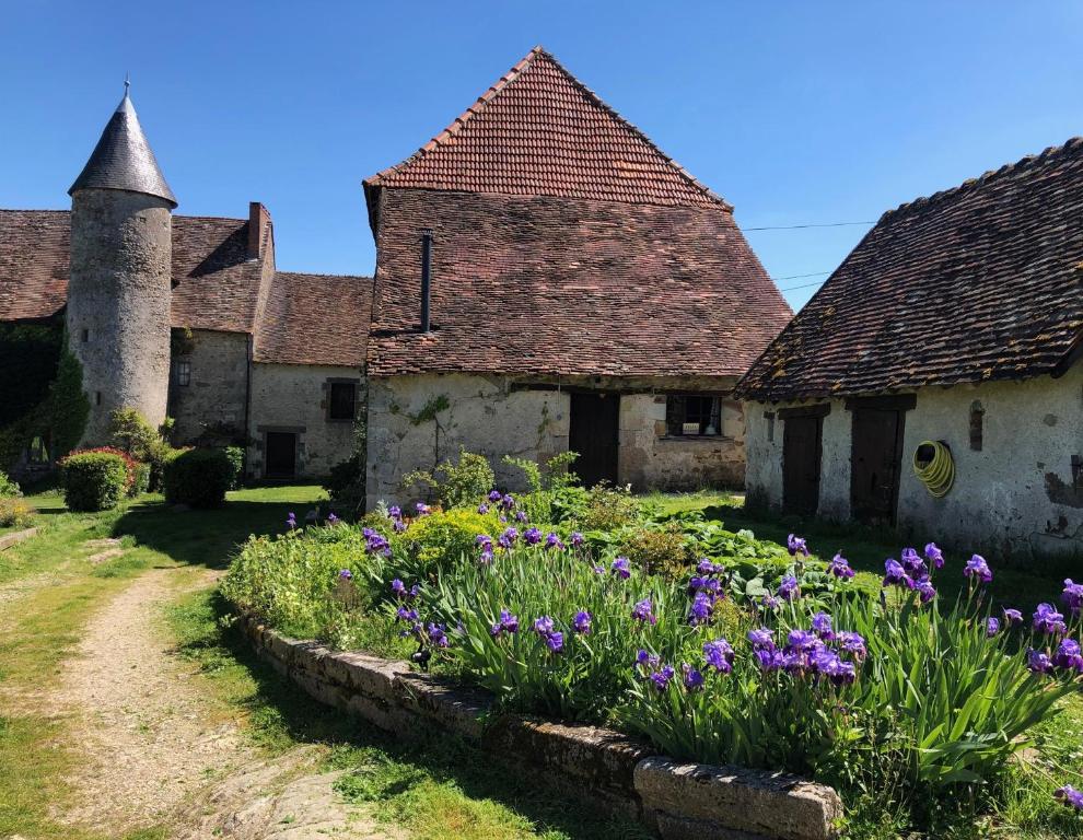 Brigueuil-le-Chantre的住宿－Chateau Mareuil，院子里一排种满鲜花的老房子