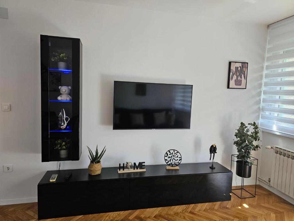 卡爾洛瓦茨的住宿－Apartman Laura，客厅配有黑桌和平面电视。
