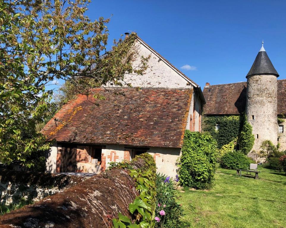 an old house with a turret and a grass yard at The Petit Prince Studio at Chateau Mareuil in Brigueuil-le-Chantre