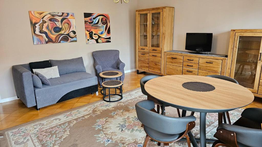 ein Wohnzimmer mit einem Tisch und einem Sofa in der Unterkunft Apartament na Kazańskiej in Łomża