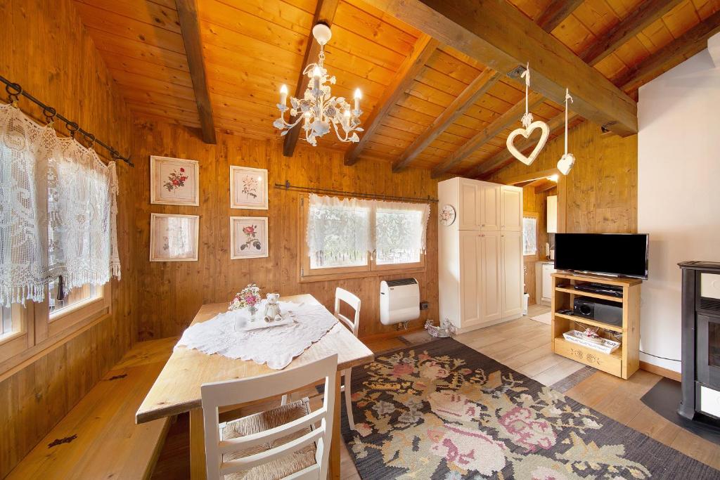 a dining room with a table and a chandelier at Orserose Chalet 8 I Fer Da Stir in Forno di Zoldo